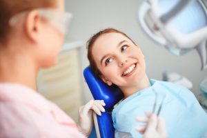 woman smiling while sitting in the dentist chair