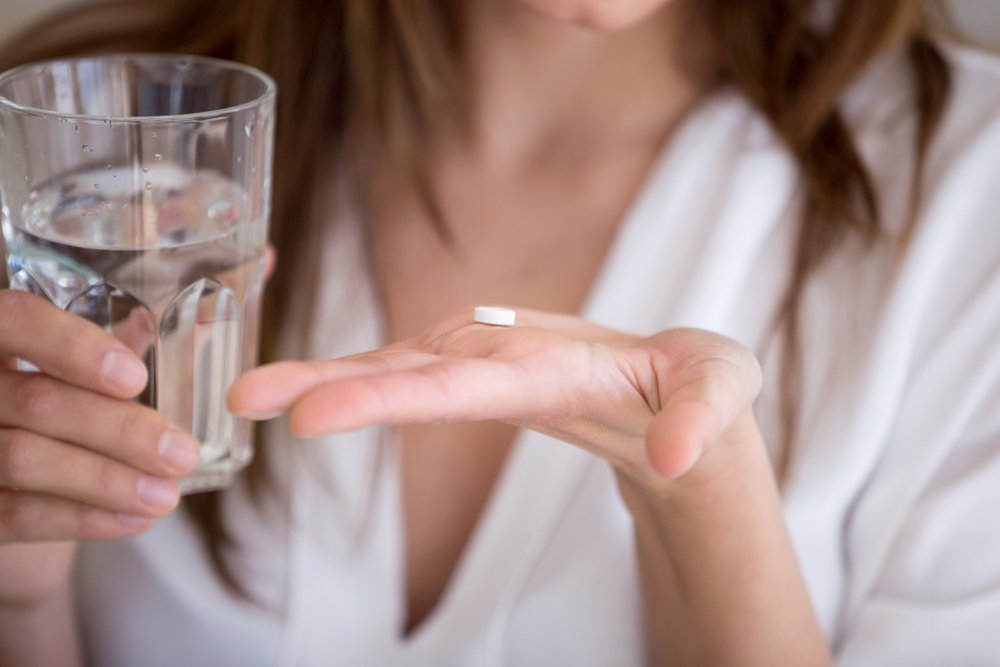 woman taking oral conscious sedation pill before the dentist